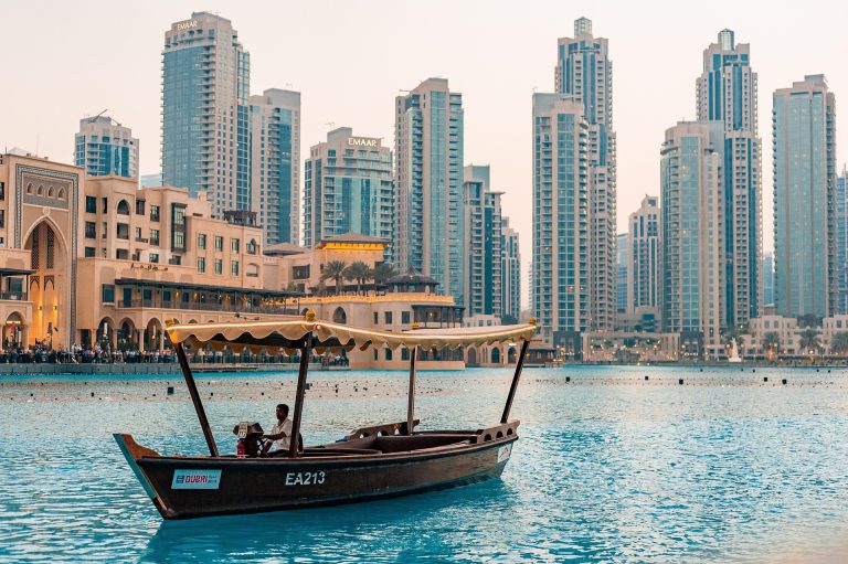 In the foreground a boat on the water, in the background Dubai's skyline
