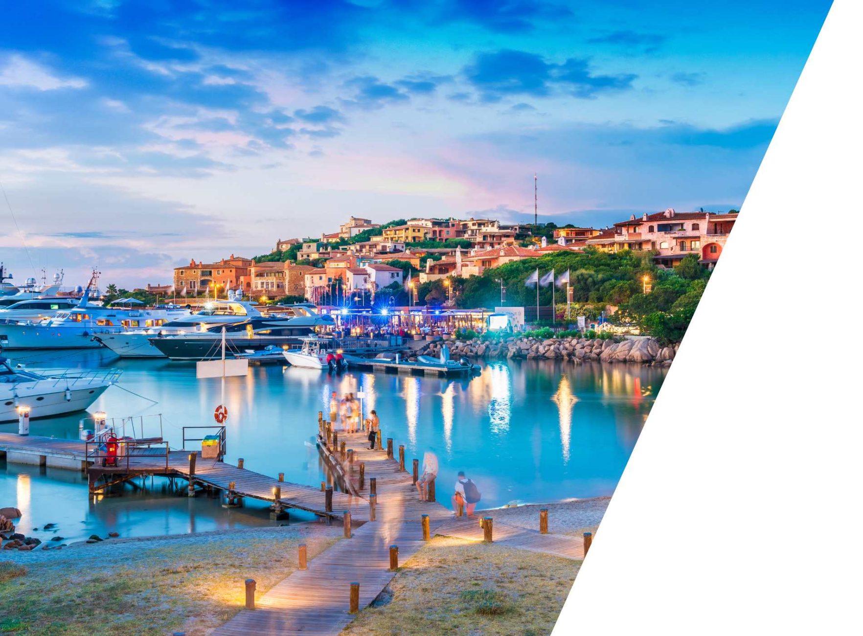 Evening mood in a Mediterranean harbor with yachts and colorful houses by the water.