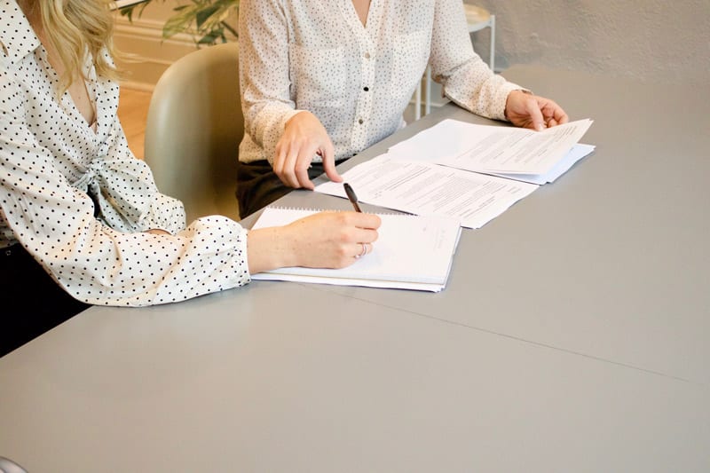 two woman doing paperwork