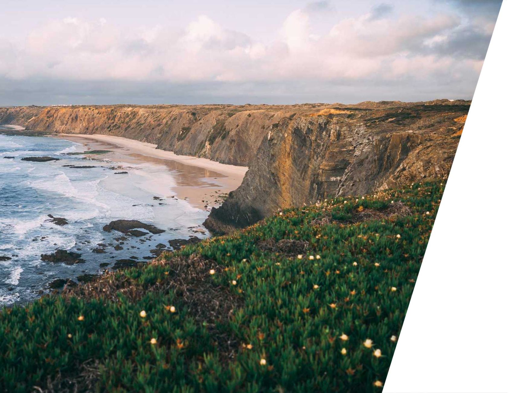Study in Lisbon Portugal activities- beach surrounded by cliff with grass above it