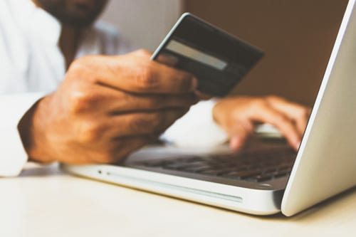 Man holding his credit card and computer