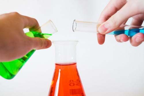 two hands filling up a cups with unknown liquid