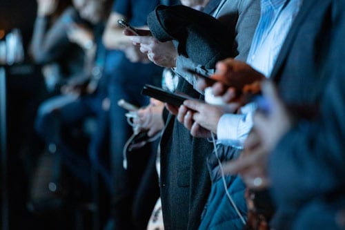 many hands holding phones