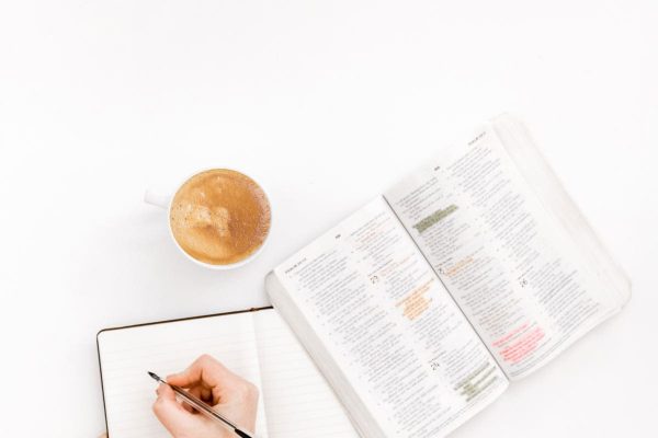 writing hand with a book and coffee