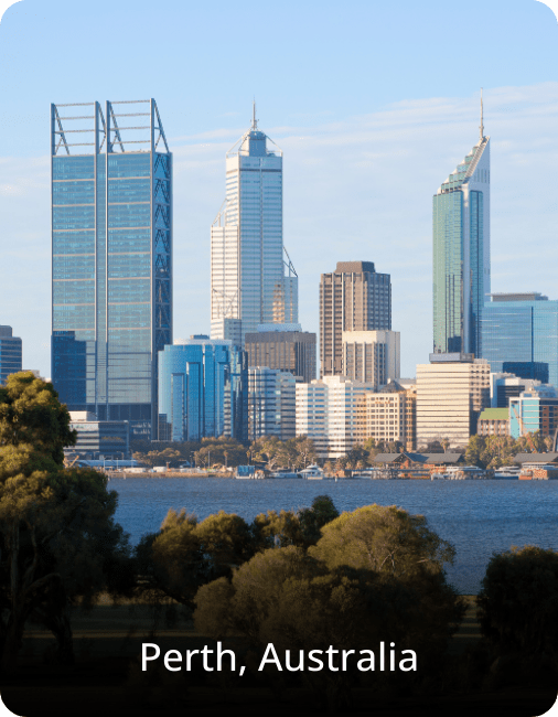 Skyline of Perth, Australia, featuring modern high-rise buildings set against a clear blue sky with greenery in the foreground.