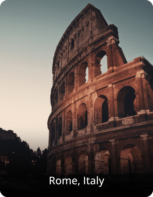 The Colosseum in Rome illuminated at night, with golden lighting highlighting the ancient stone arches against the dark sky.