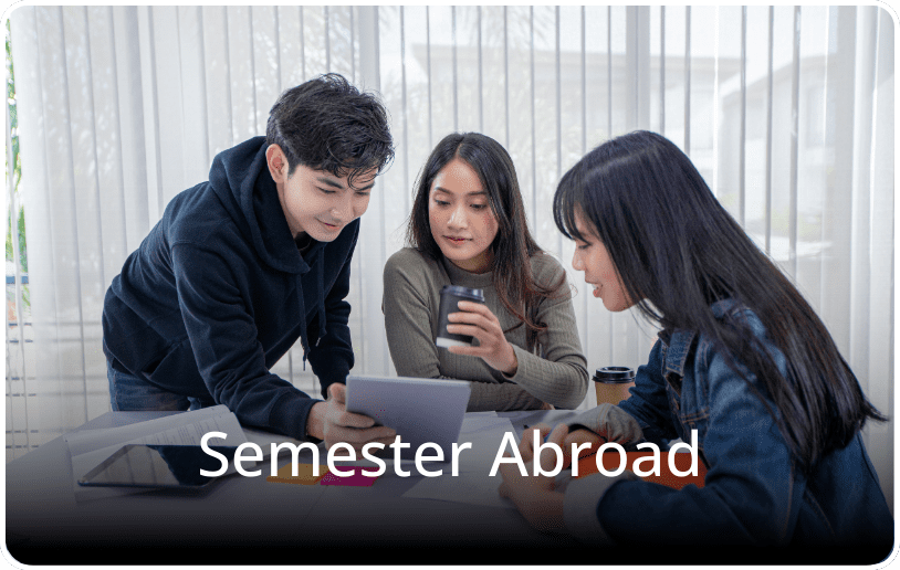 Three students sitting around a table looking at a tablet together, with the text “Semester Abroad” overlaid on the image.