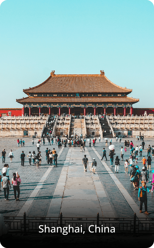 Traditional temple in Shanghai with ornate Chinese architecture, featuring curved roofs and red and gold detailing in an urban setting.